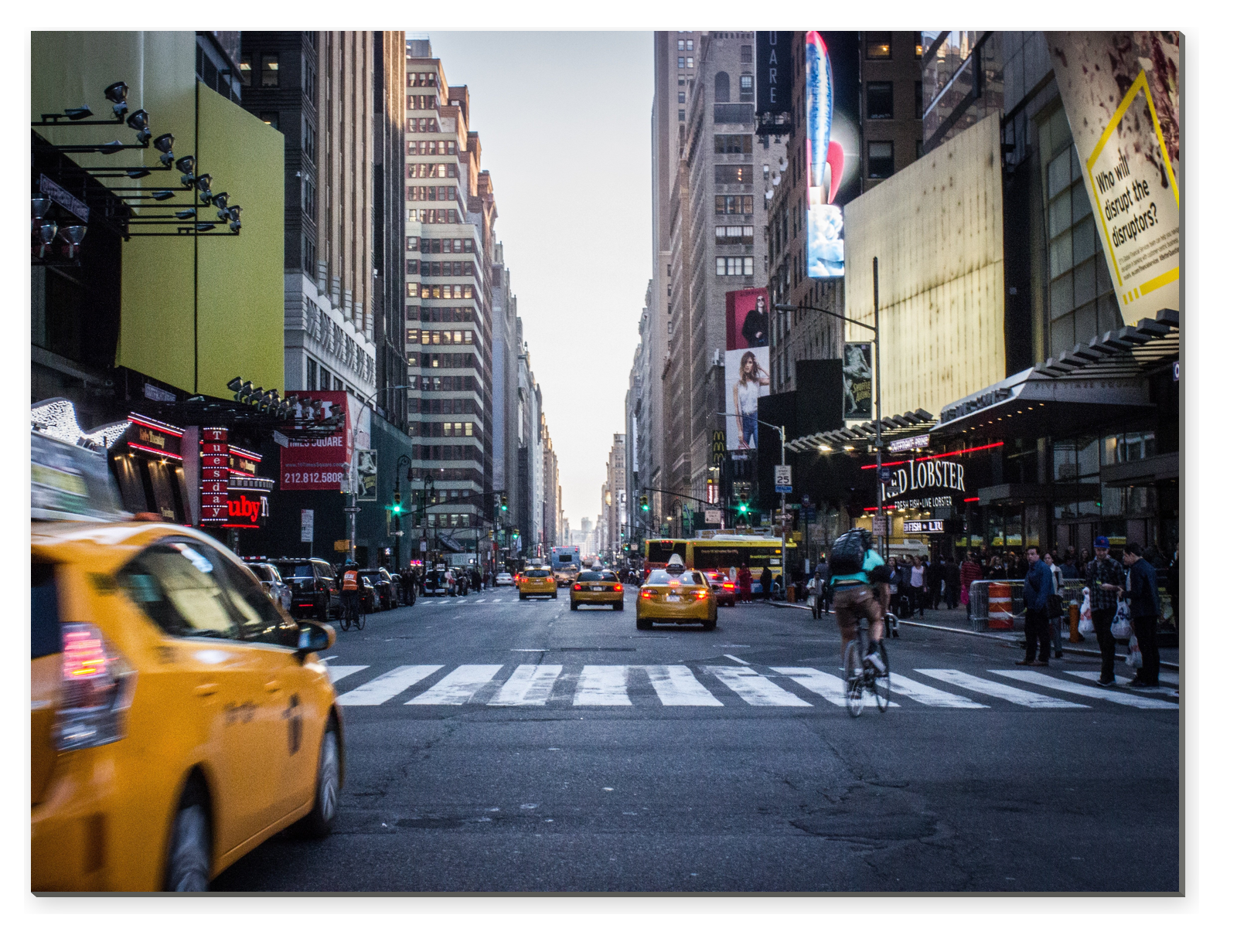 Rušná ulice v New Yorku se žlutými taxíky, chodci a vysokými budovami