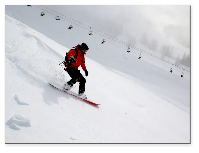 Snowboardista na zasněženém svahu